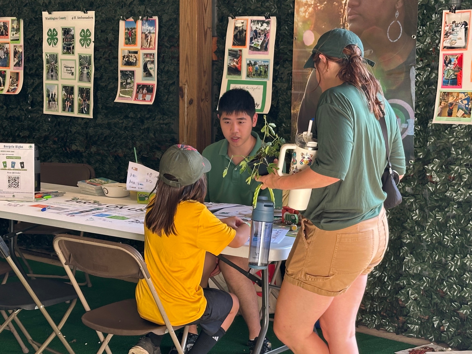A family visiting the Earth on Us table and talking with Daniel