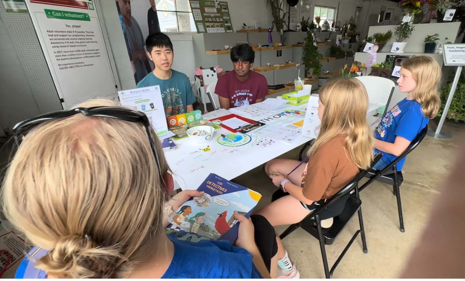 Visitors talking with Earth on Us volunteers and reviewing curriculum materials
