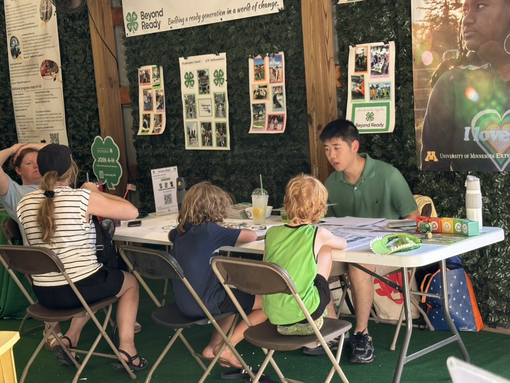 Daniel and youth gathered around the Earth on Us table in the 4-H Lounge
