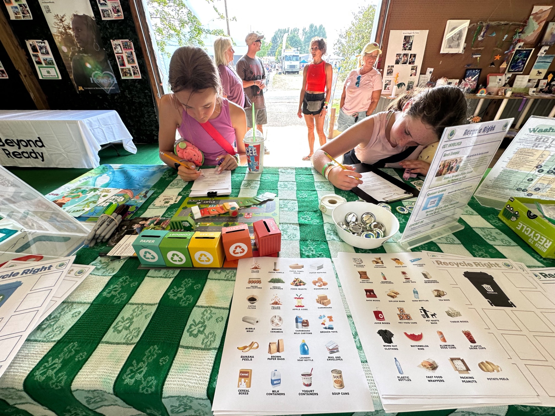 Visitors signing the Recycle Right pledge next to sorting posters and bins